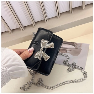 Detailed close-up of a mini black leather crossbody bag featuring a silver bow metal buckle