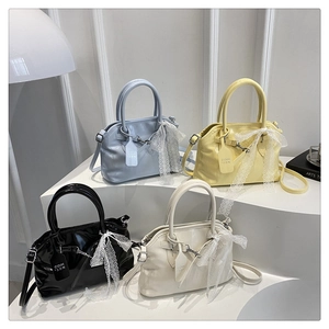 Détail de sacs carrés en cuir verni avec des nœuds en dentelle en plusieurs couleurs