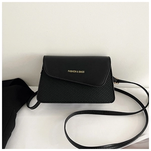 Detail of black square crossbody bag with irregular flap and textured stripe pattern