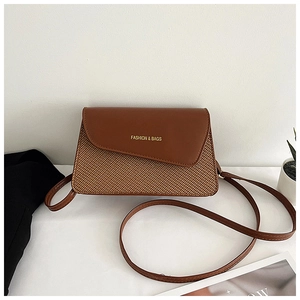 Close-up of brown woven square crossbody bag with leather flap and fashion lettering