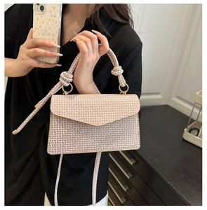 Détail d'un sac à bandoulière beige et marron avec poignée nouée et motif FF