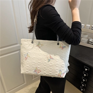 White canvas tote bag with embroidered butterfly patterns and silver chain strap