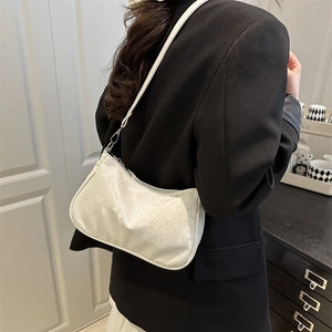 Sac bandoulière blanc motif serpent porté par un mannequin en tenue professionnelle