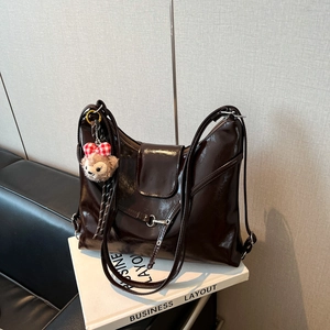 Glossy dark brown patent leather tote bag with silver buckle and bear keychain charm