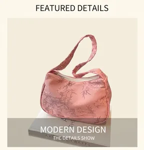 Pink shoulder bag with gray bamboo patterns placed on art books in natural light