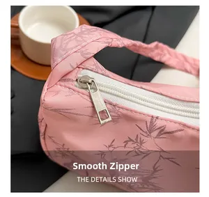 Detail showing the smooth silver zipper closure on pink floral canvas shoulder bag