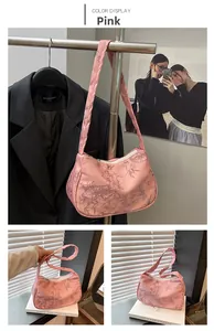 Detail of pink silk shoulder bag featuring elegant bamboo leaf patterns and top zipper