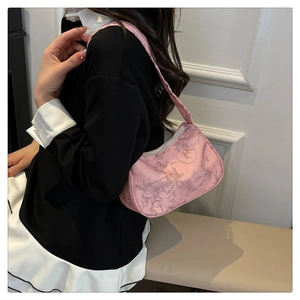 Detailed view of pink bamboo leaf print shoulder bag with crescent shape and fabric handle