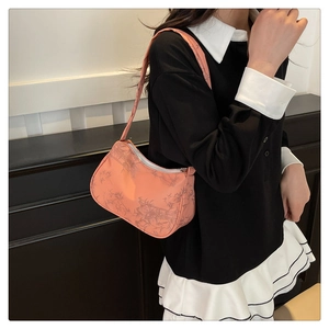 Orange pink underarm bag with grey bamboo leaf print worn over the shoulder by a model