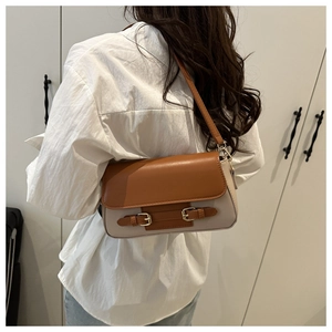 Vista trasera de un bolso bandolera bicolor con hebillas dobles lucido por una modelo