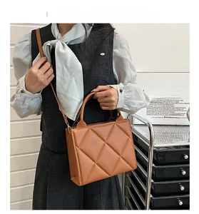 Brown quilted tote bag with diamond stitching shown in a stylish lifestyle setting