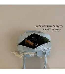 Spacious interior of a soft leather Boston bag showing phone, wallet, and cosmetics