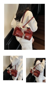 Detail of burgundy PU leather shoulder bag with glossy finish and white mesh bow accessory