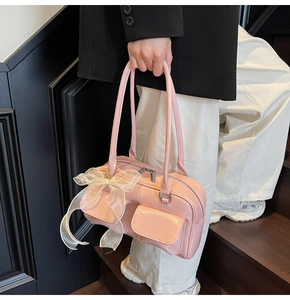 Pink soft leather shoulder bag with a large white organza bow on a model on stairs