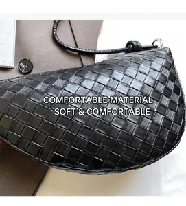 Detail shot of black woven leather croissant bag showing refined intrecciato texture and hardware