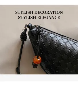 Close-up of woven leather bag featuring a distinctive amber bead detail on the strap knot