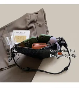 Interior view of black woven crescent bag showing large capacity for phone and wallet