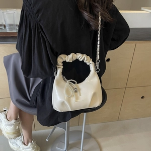 White ruched underarm bag with pearl bow pendant and metal chain strap in high-end style