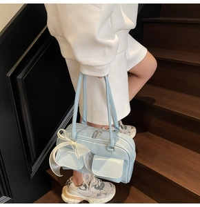 Detail of light blue faux leather Boston bag with a large decorative white mesh bow