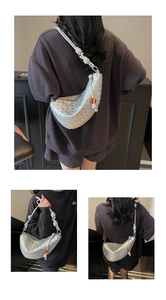 Detalle del bolso trenzado plateado con correa de nudo y detalle de cuenta ámbar