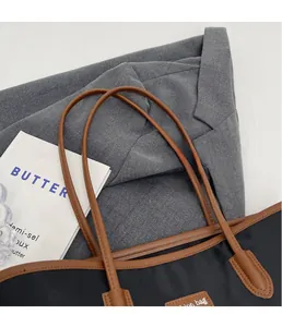 Details eines schwarzen Nylon-Shoppers mit Ledergriffen auf Blazer und Magazin