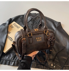 Close-up of retro brown Boston bag featuring golden hardware and leather texture details