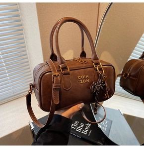 Detailed shot of a vintage brown Boston handbag with ribbon bow and metal key charm