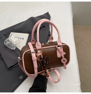 Detail of retro color-block baseball bag with tennis racket charm and pink handles
