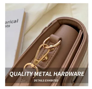 Makroansicht der goldenen Metallhaken und Nähte an einer braunen Lederhandtasche
