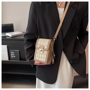 Detail der gesteppten Crossbody-Handytasche mit goldenem Schloss und Bärenanhänger