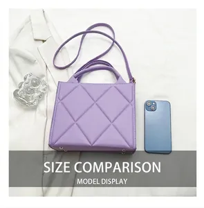 Macro shot of lavender quilted crossbody bag with metal feet and smartphone for size scale