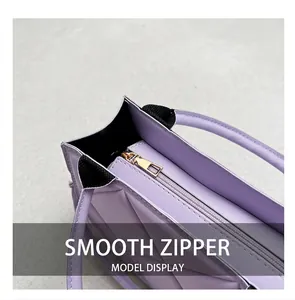 Detail of smooth gold zipper closure on light purple quilted handbag with leather texture