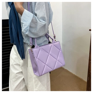 Detail of lilac quilted tote bag showing geometric stitching and rounded double handles