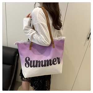 Close-up of purple gradient canvas tote bag featuring fringe trim and Summer text