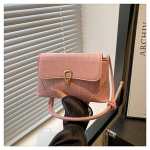 Close-up of pink crocodile pattern small square bag with golden horseshoe buckle details