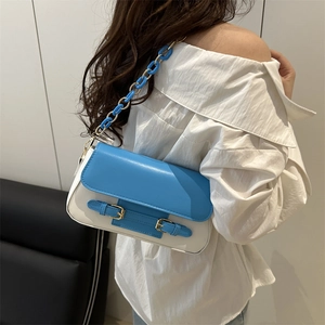 Bolso de hombro bicolor azul y blanco con cadena decorativa de metal y resina