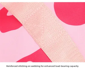 Reinforced cross-stitching on pink travel bag straps for enhanced weight capacity