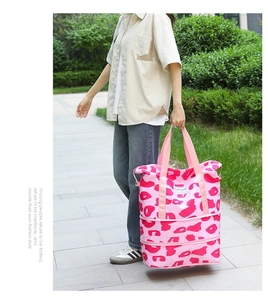 Detail of pink leopard print travel bag featuring expandable zipper layers and nylon handles