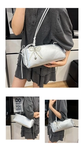 Nahaufnahme der silbernen Tasche mit Perlen-Schleife, Spitze und Herz-Anhänger