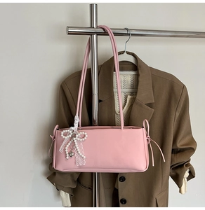 Pink underarm bag detail with delicate white lace pearl bow and heart metal pendant
