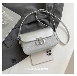 Détail du sac argenté avec boucle en métal CD et texture scintillante de strass