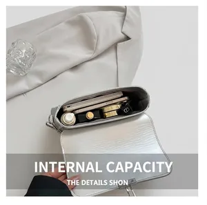 Vue intérieure détaillée du sac à main argenté montrant le rangement des essentiels