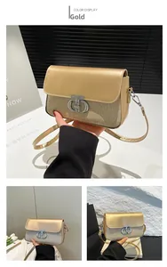 Détail du sac à main doré avec paillettes et boucle métallique argentée entrelacée