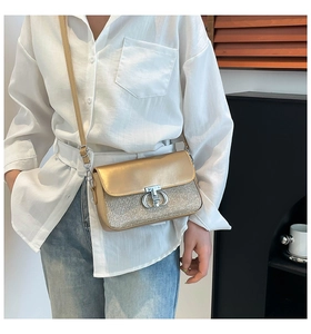 Détail du sac bandoulière à paillettes dorées avec boucle métallique argentée chic
