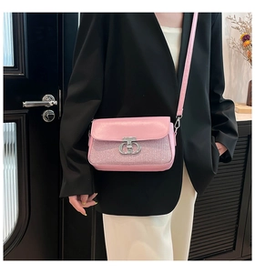 Détail du sac carré rose pailleté avec boucle en métal argenté et bandoulière mince