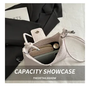 Détail d'un sac tressé montrant l'espace de rangement pour téléphone et portefeuille