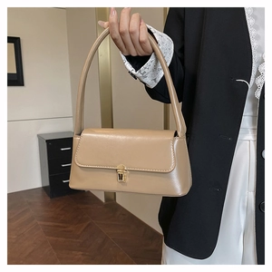 Sac sous le bras chic en simili cuir kaki avec boucle dorée dans un décor d'intérieur