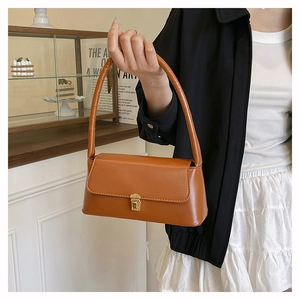 Détail du sac sous le bras marron vintage avec fermoir doré et poignée épaisse