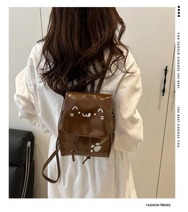 Vue de dos d'un mannequin portant le mini sac à dos en cuir marron brillant à motif chat