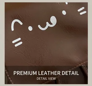 Detail of dark brown leather bag showing white cat pattern and neat stitching craft